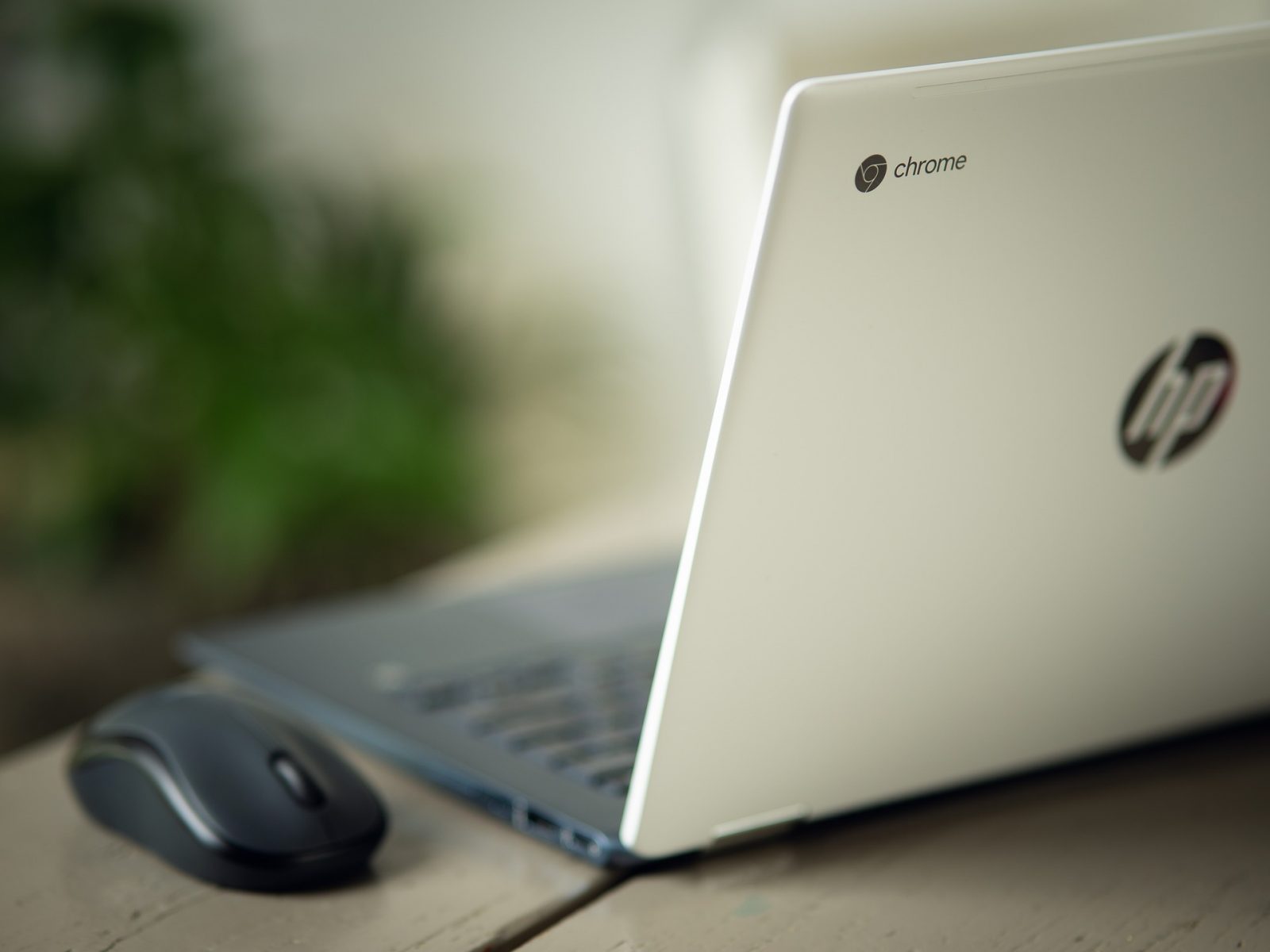 An open Chromebook with a mouse next to it.