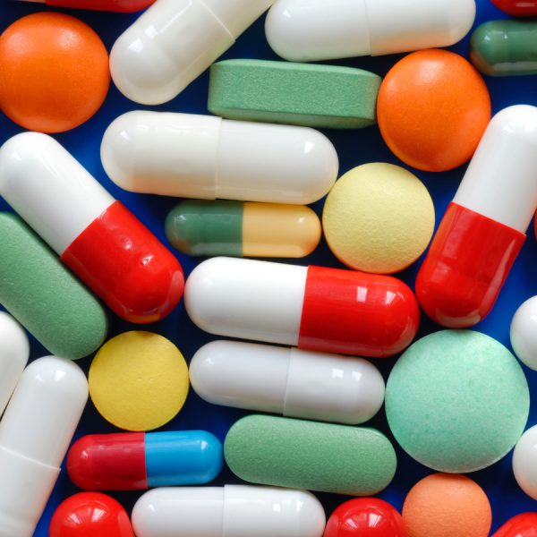A photo of a pile of pills and a thermometer.