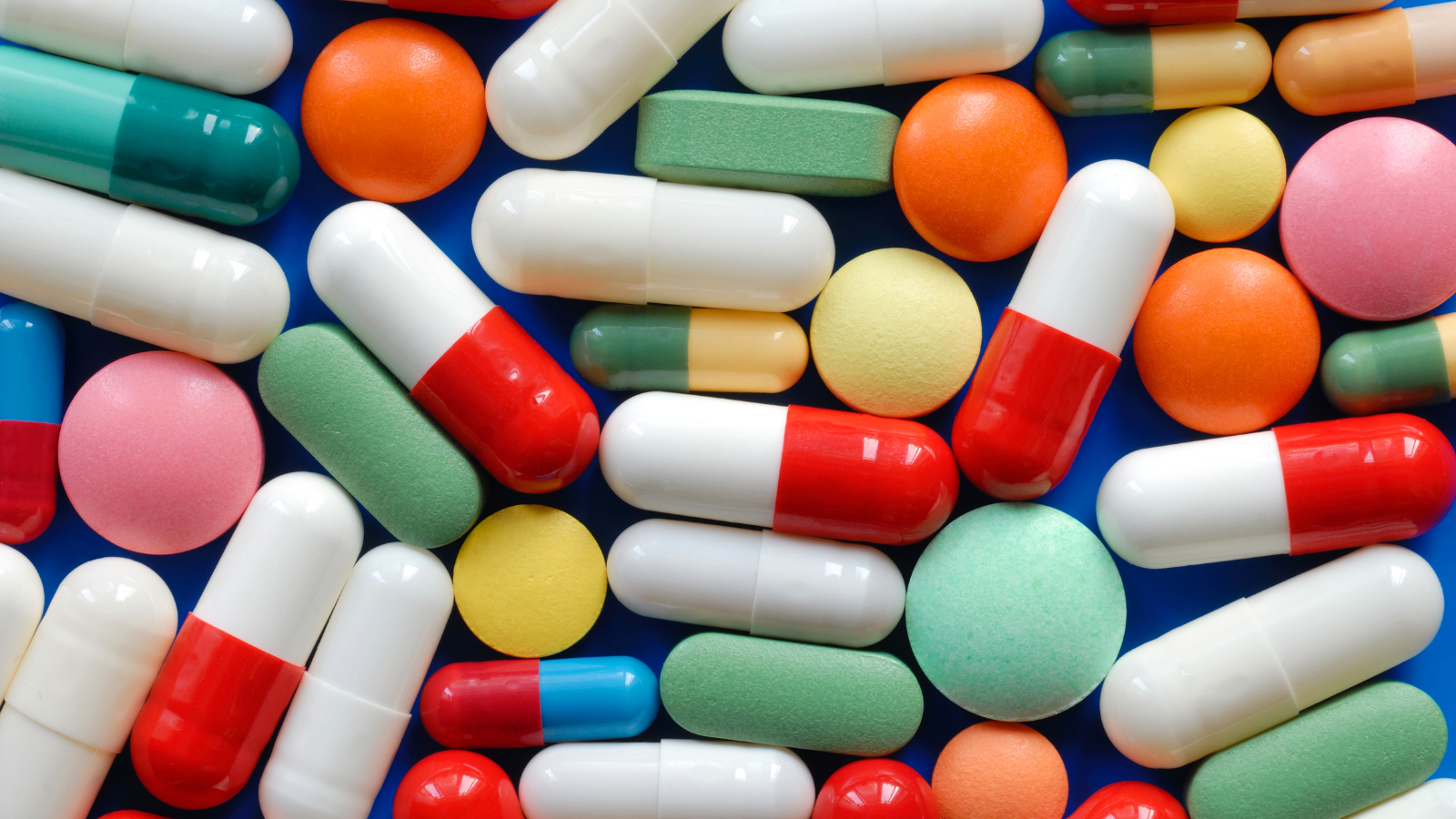 A photo of a pile of pills and a thermometer.
