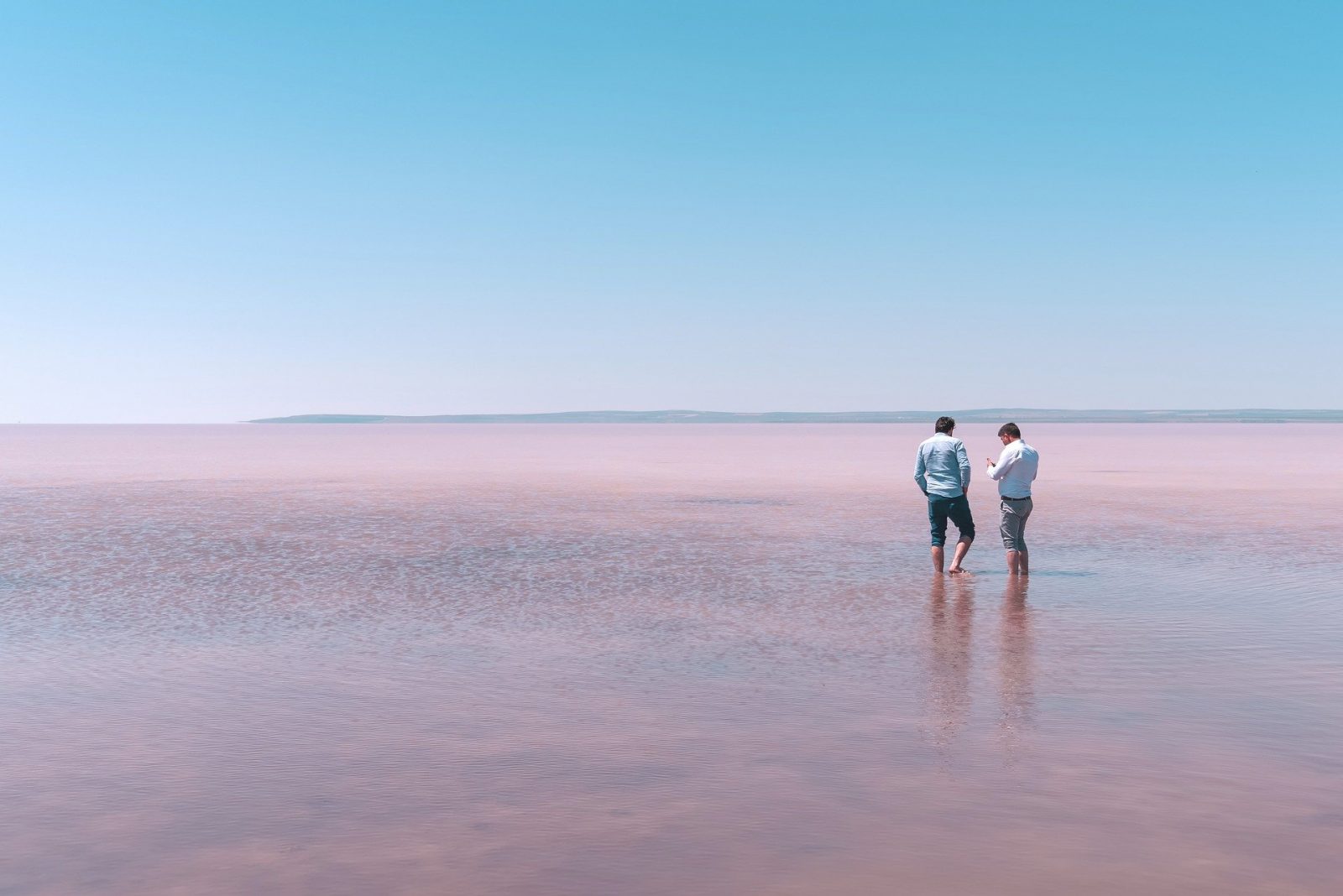 Two men standing in a lake talking to each other