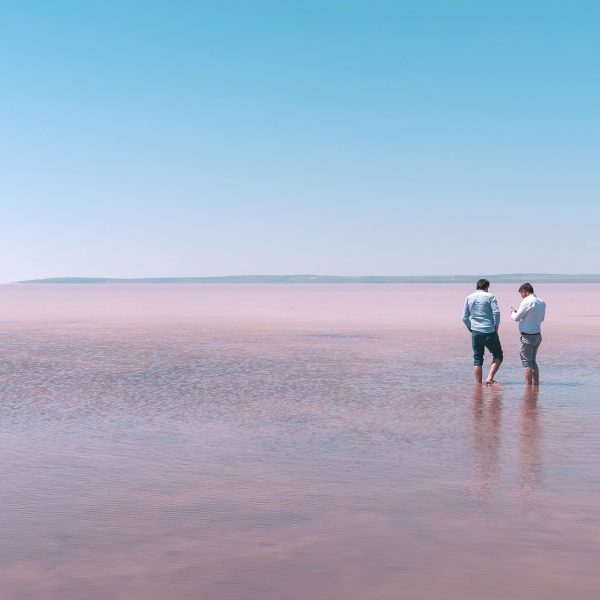 Two men standing in a lake talking to each other