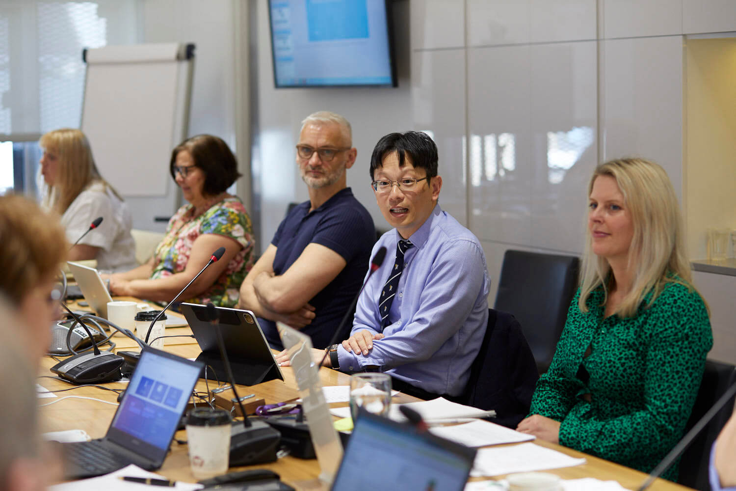 A picture of Bernie Chang chairing a meeting at the RCOphth