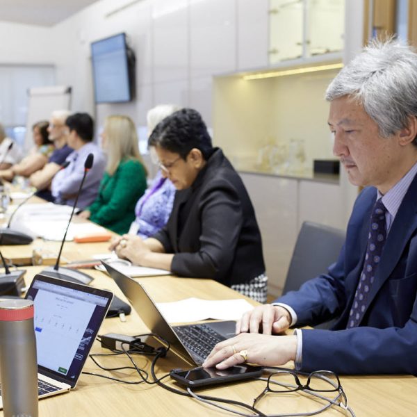 A photo of Chris Liu on his laptop during a meeting at the RCOphth