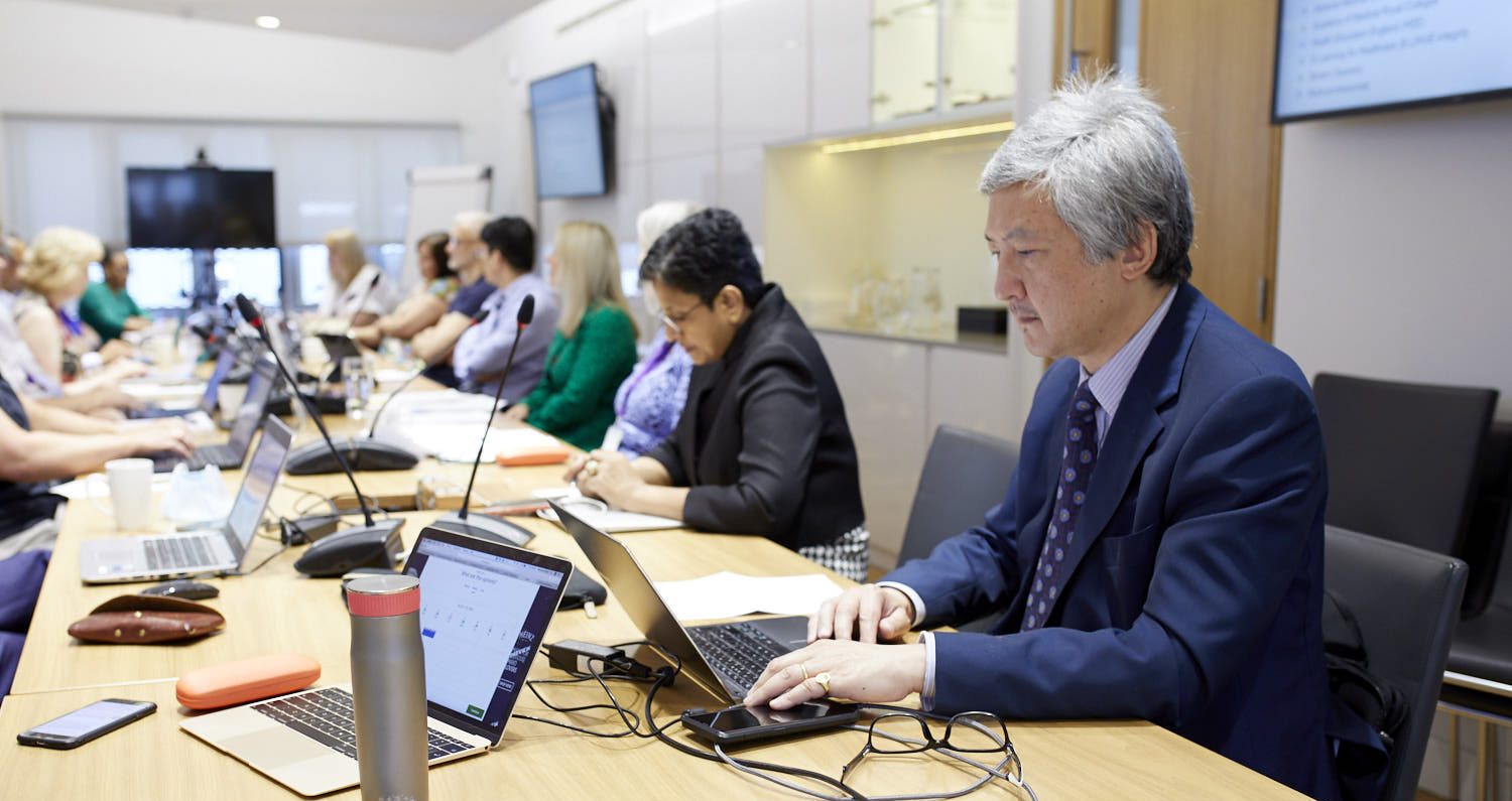 A photo of Chris Liu on his laptop during a meeting at the RCOphth