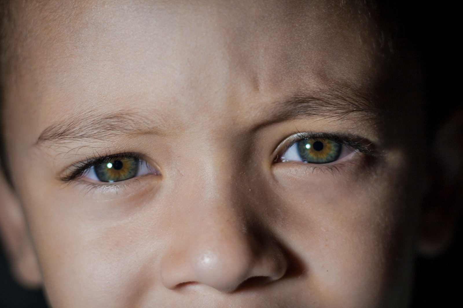 A photo of the top half a a boy's face. He is looking directly at the camera.