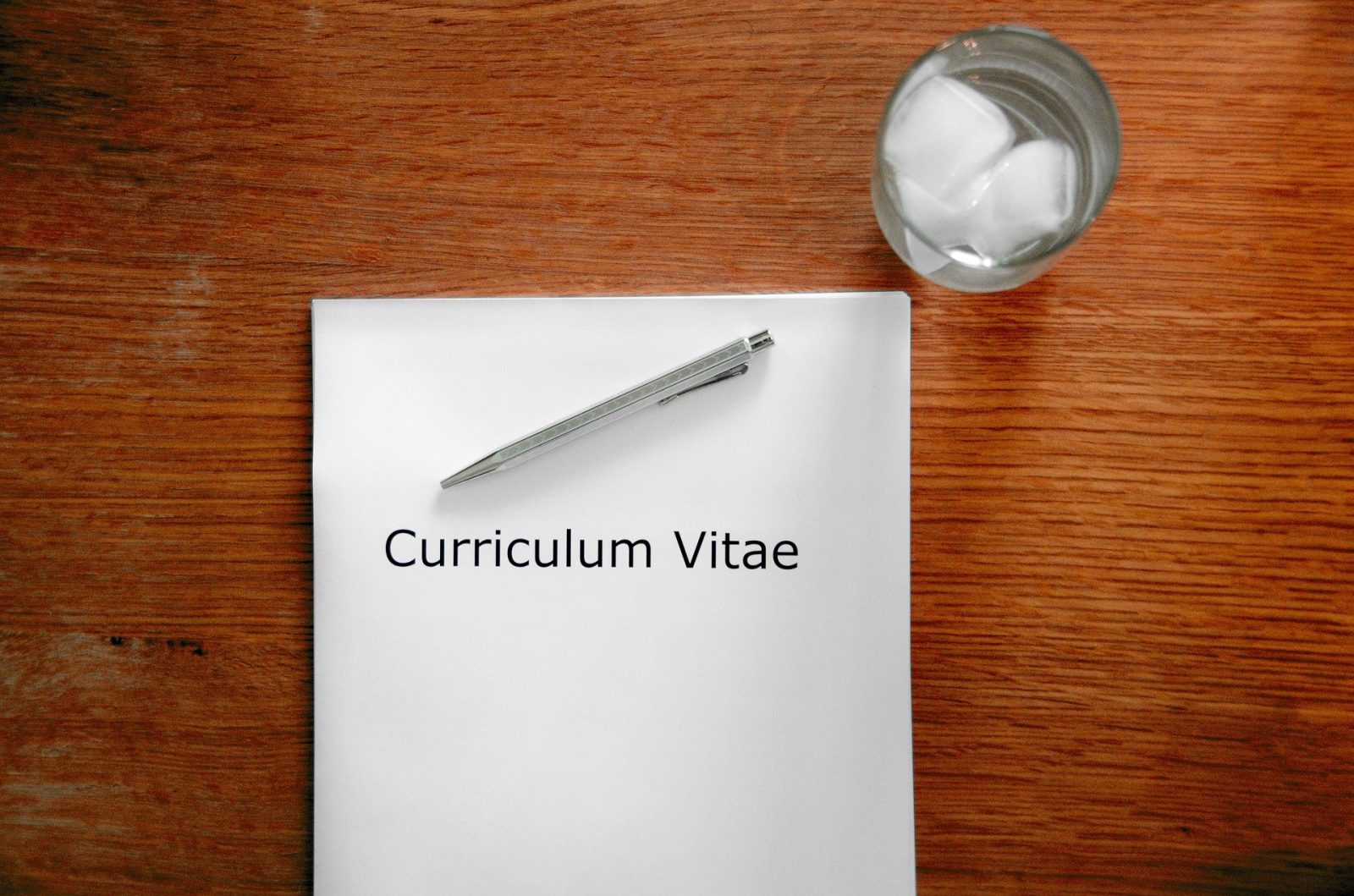 A photo of a CV and a glass of water: Image by Tobias Herrmann from Pixabay