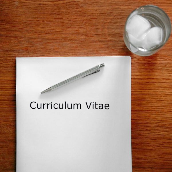 A photo of a CV and a glass of water: Image by Tobias Herrmann from Pixabay